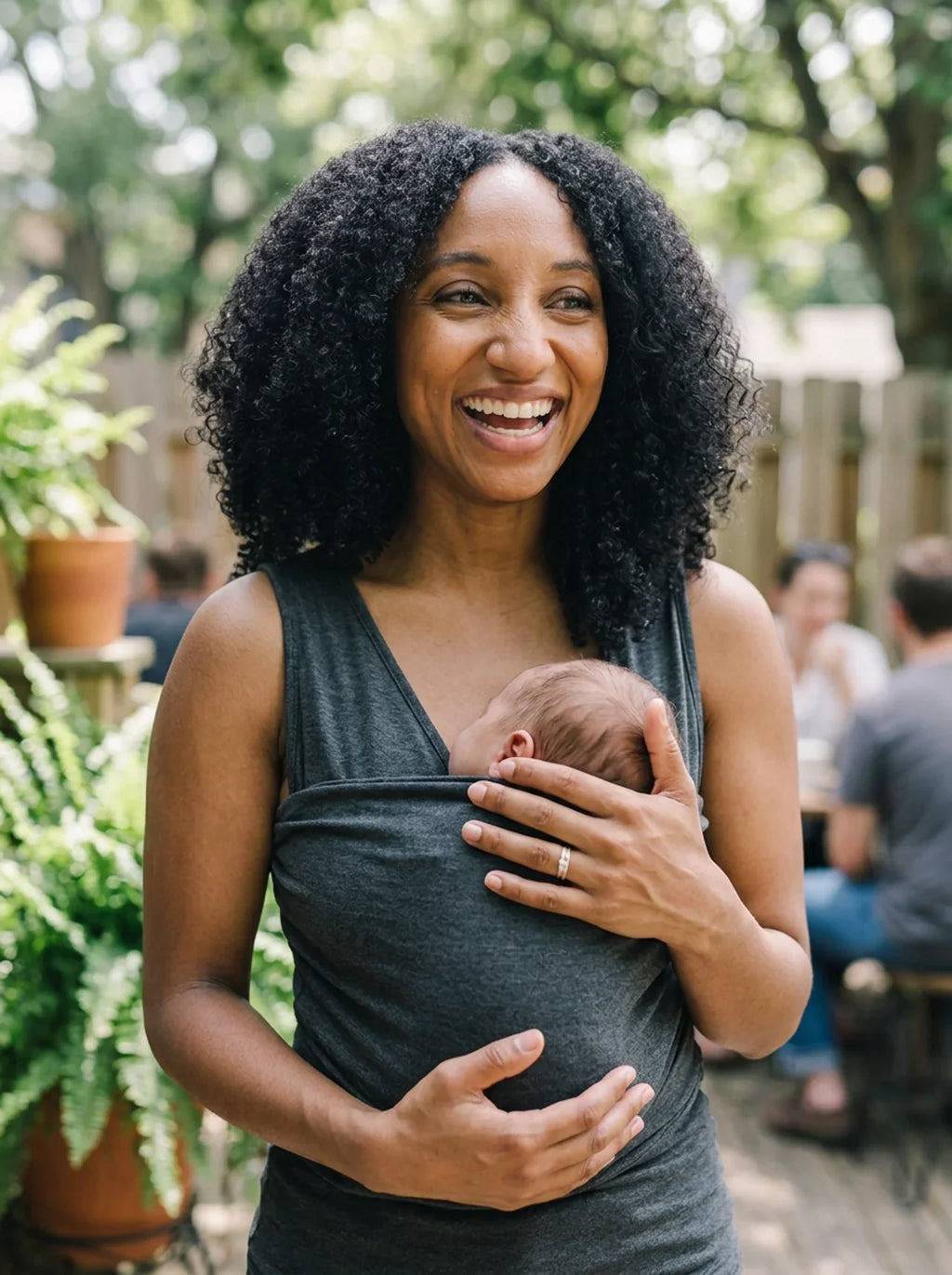 Débardeur porte-bébé Hugaya porté par une mère, bébé installé contre elle, coloris gris