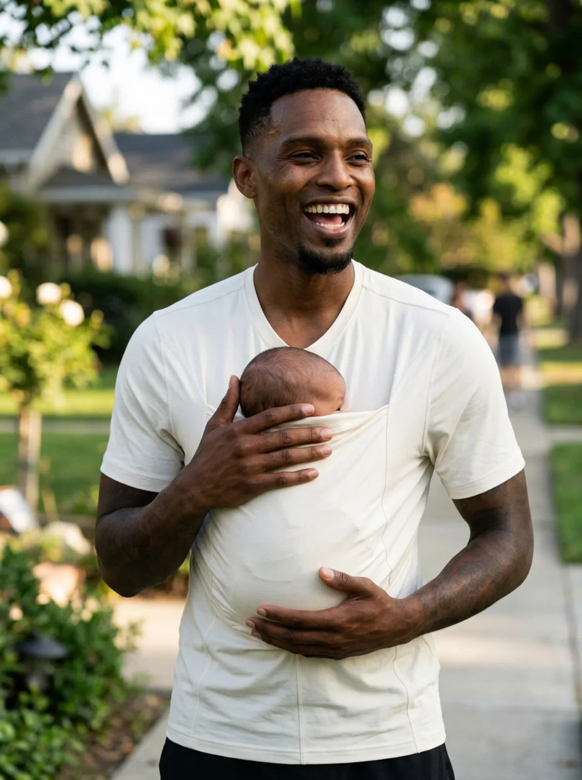 T-shirt porte-bébé Hugaya porté par un père, bébé installé contre lui, coloris blanc