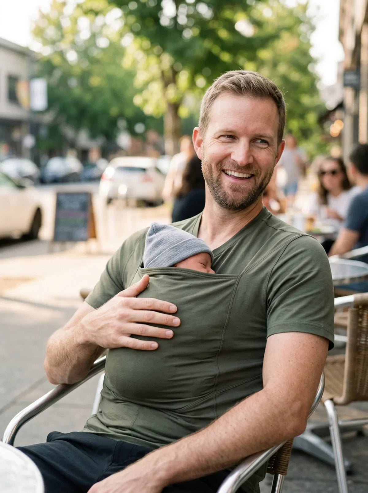 T-shirt porte-bébé Hugaya porté par un père, bébé installé contre lui, coloris vert